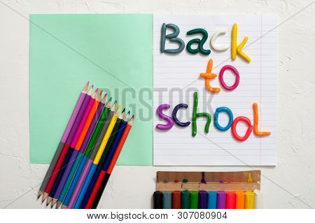 School Supplies And Inscription Back To School On Color Background