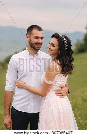 Beautiful Young Wedding Couple Standing On The Green Slope, Hill. Groom And Bride In Carpathian Moun