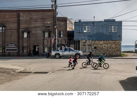 Nome, Alaska - June 8: Children Play And Ride Bicycles On The Historic Front St On June 8 2019 In No