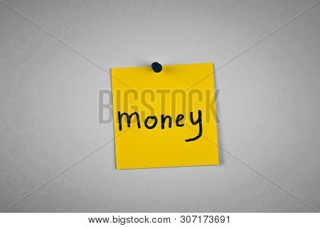 The Word Money On A Piece Of Yellow Paper Among Multicolored Paper