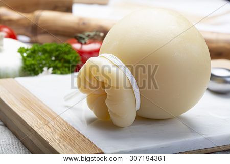 Italian Provolone Or Provola Caciocavallo Hard Cheese In Teardrop Form Served On White Marble Plate