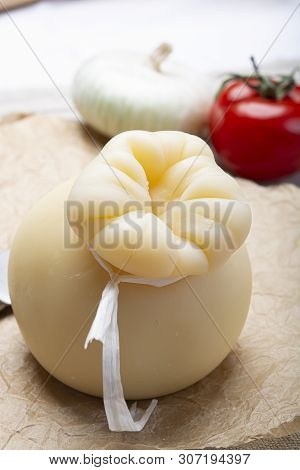 Italian Provolone Or Provola Caciocavallo Hard Cheese In Teardrop Form Served On Old Paper Close Up