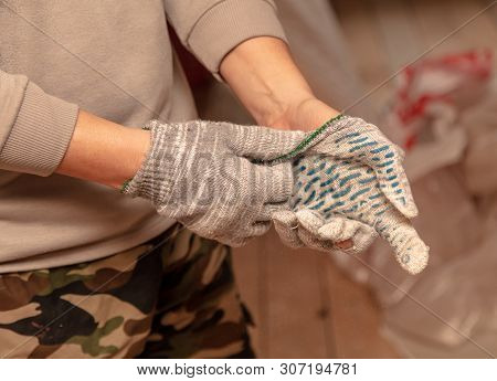 Worker Takes Off Gloves From Hands At A Construction Site.