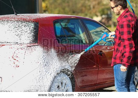 Manual Car Wash With Pressurized Water In Car Wash Outside.summe Washing. Cleaning Car Using High Pr