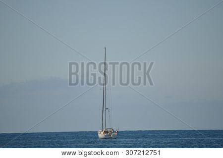 Sailboat Seen From A Black Sand Beach On A Sunny Day In The Great Tarajal. July 4, 2013. Gran Taraja