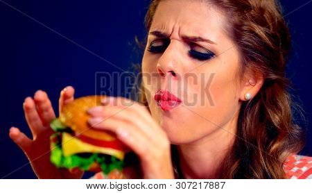 Girl close up eats cheeseburger. Take away fast food most popular food of youth.