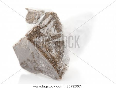 Sostanza cercando esattamente come hashish in plastica avvolgimento, isolato