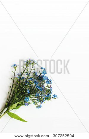 A Small Cute Bouquet Of Blue Forget-me-nots Lies On A White Table. Selective Focus. There Is Room Fo