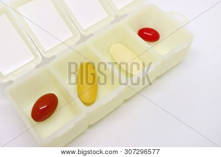 Assorted Supplement Pills In An Opened Daily Pill Organizer Case