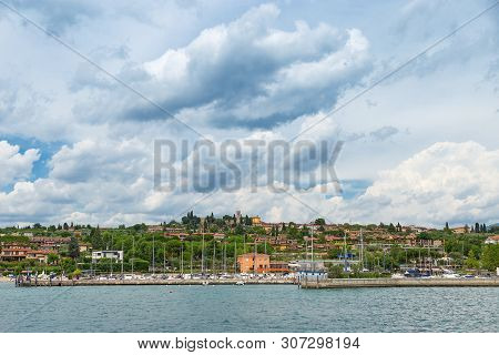 The View From The Water On The Coast Of The Small Italian Town Of Manerba Del Garda. Natural Scenery