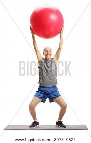 Full length portrait of an elderly man exercising with a fitness ball isolated on white background