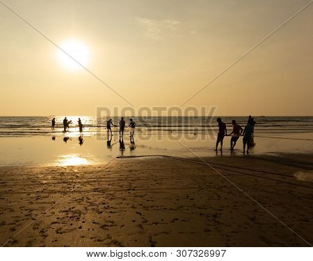 Goa, India - December 20, 2018: Fishermen Fishing With Nets On Morjim Beach