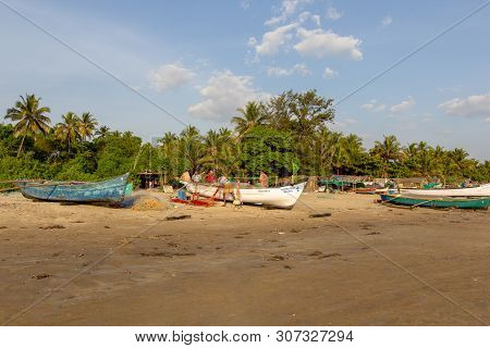 Goa, India - December 20, 2018: Fishermen Prepare Tackle And Boats On Morjim Beach