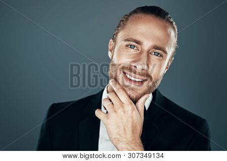 He Got The Look. Charming Young Man In Bow Tie Looking At Camera And Keeping Hand On Chin While Stan