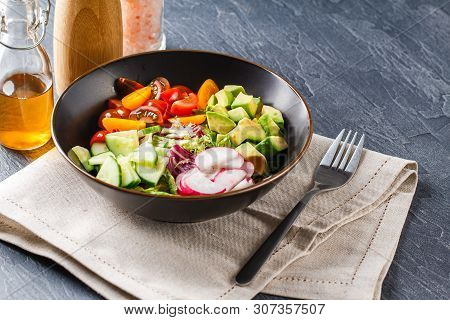 Vegan Buddha Bowl. Bowl With Fresh Raw Vegetables - Cherry Tomatoes, Cucumber, Radish, Avocado, Lett