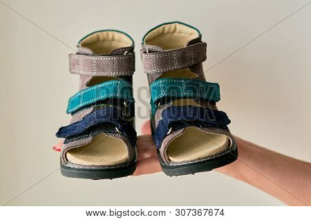 Female Is Holding Close-up A Special Childrens Orthopedic Shoe Sandals Made Of Genuine Leather.
