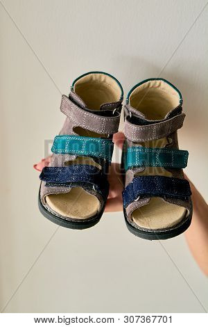 Female Is Holding Close-up A Special Childrens Orthopedic Shoe Sandals Made Of Genuine Leather.