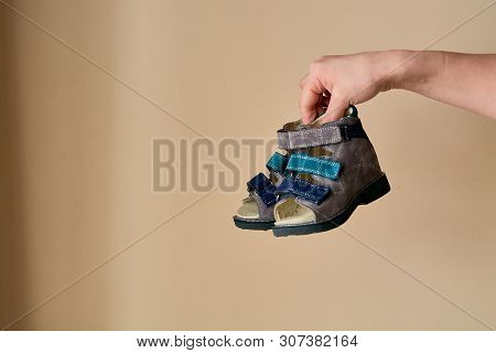 Female Is Holding Close-up A Special Childrens Orthopedic Shoe Sandals Made Of Genuine Leather.