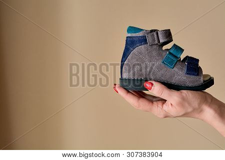 Female Is Holding Close-up A Special Childrens Orthopedic Shoe Sandals Made Of Genuine Leather.
