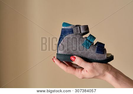 Female Is Holding Close-up A Special Childrens Orthopedic Shoe Sandals Made Of Genuine Leather.