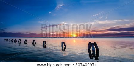 Beautiful Sunset At Lake, Sea With Wooden Piers In The Front