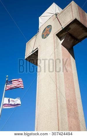 2019 BLADENSBURG MARYLAND USA FEB 25 Peace Cross: Low angle view of American Flag, 100th anniversary Flag at the World War I Memorial commissioned by the American Legion built 1919-1925 on Alt Rt 1.