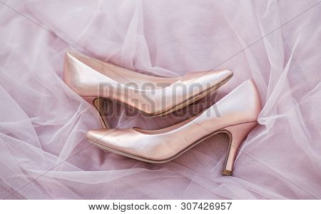 Pink Gold Bridal Shoes. Tender Beige Fatin Cloth Texture Background. Top View Of Ladys Pumps. Space 