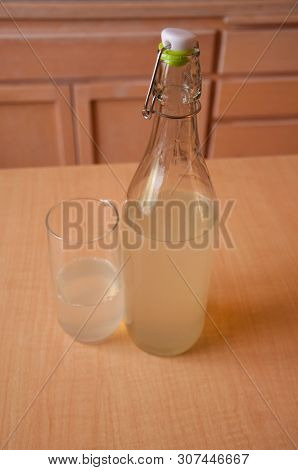 Water Kefir Beverage Is In A Liter Glass Bottle With The Cap Off, Poured In A Glass.  This Healthy D
