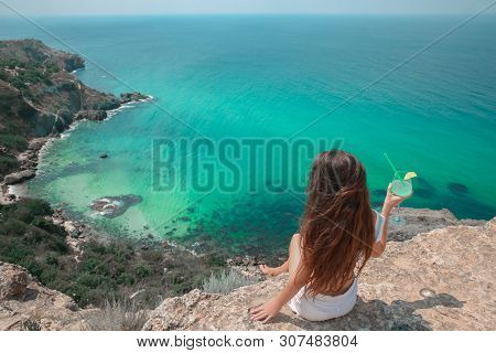 Summer Girl Traveller Concept. Sexy Brunette With Coctail Glass On Cliff Mountains Enjoying Lagoon B