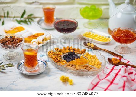 Tea Set With Varieties Of Traditional Nuts, Lemon, Confiture And Sweets Served On White Tablecloth -