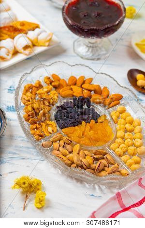 Tea Set With Varieties Of Traditional Nuts, Lemon, Confiture And Sweets Served On White Tablecloth -