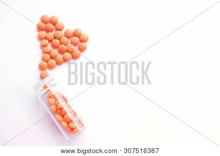 Heart Made Of Orange Tablets And Glass Bottle On White Background. Copyspace For Text. Epidemic, Pai