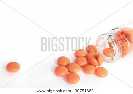 Orange Tablets From Glass Bottle On White Background. Copyspace For Text. Epidemic, Painkillers, Hea
