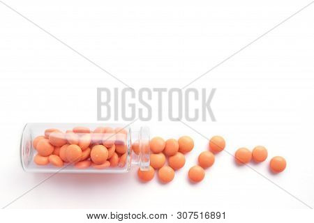 Orange Tablets From Glass Bottle On White Background. Copyspace For Text. Epidemic, Painkillers, Hea