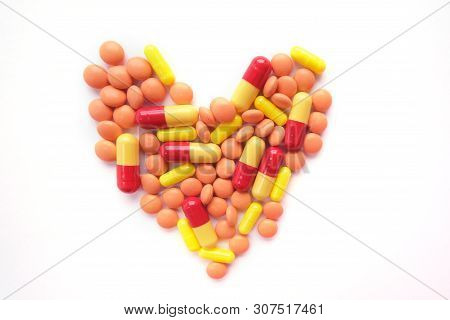 Heart Made Of Multicolor Tablets On White Background. Epidemic, Painkillers, Healthcare, Treatment P