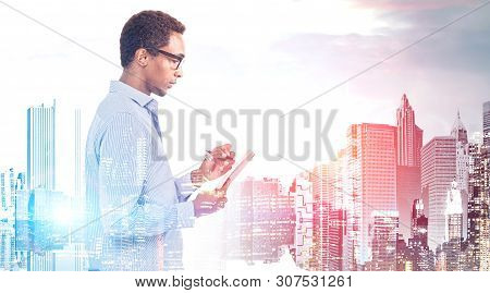 Side View Of Serious Young African American Man In Glasses And Shirt Taking Notes In City. Concept O