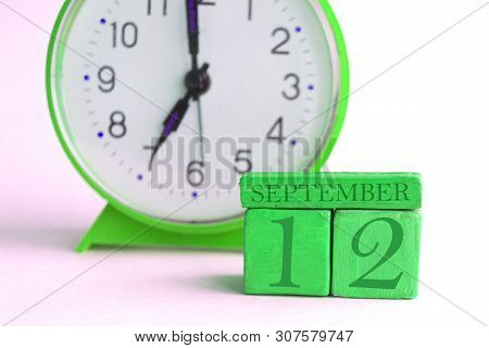 September 12th. Day 12 Of Month, Handmade Wood Calendar And Alarm Clock On Light Green Color. Autumn