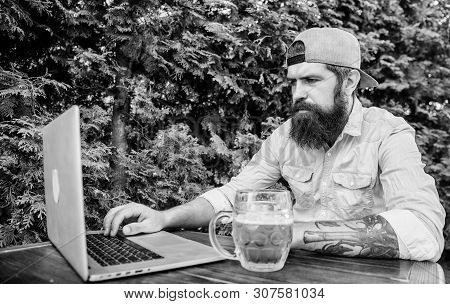 Taking The Online World And Beer Mug With Him. Computer Keyboard Operator. Computer User Drinking Be