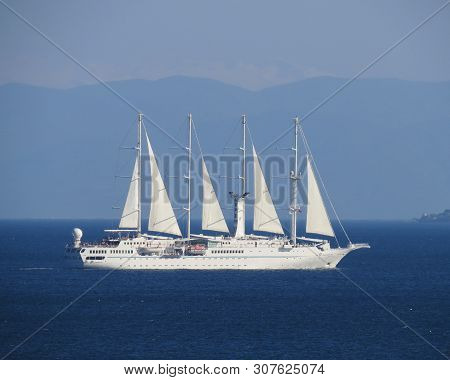 A Four-mast White Ship Under Sail Moves Across The Blue Sea. Close-up.