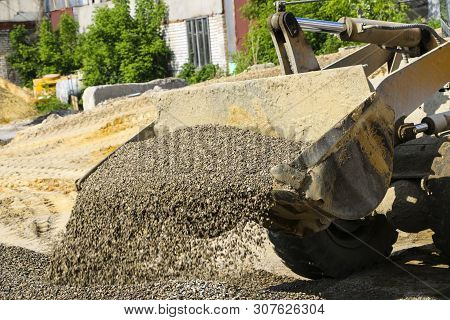 Tractor Collects Scoop With  Gravel. Excavator Extracts Sand And Gravel For  Concrete Mix.