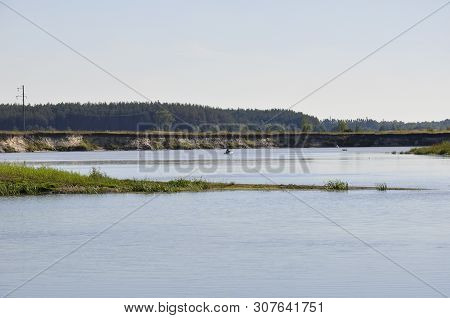 Wide Blue River Is Slow Flowing. Summer. Sunny Weather And White Sand. Green Trees Far Away