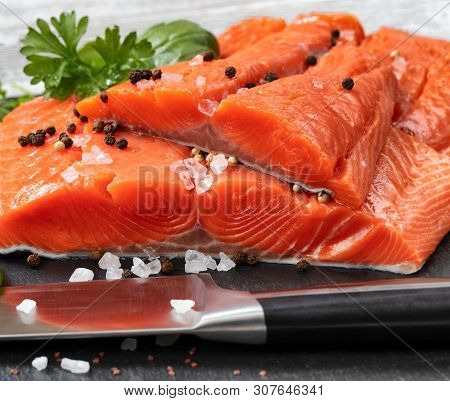 Fresh Raw King Salmon Fillets On Natural Stone With Herbs And Seasoning