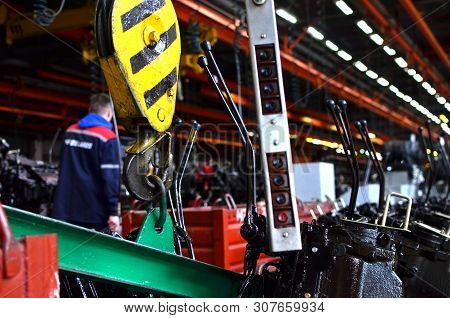 Bridge Lifting Crane Hook Against The Background Of The Assembly Line Industrial Factory. The Concep