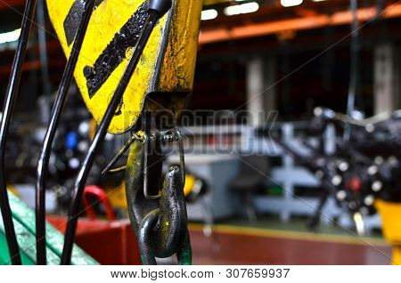 Bridge Lifting Crane Hook Against The Background Of The Assembly Line Industrial Factory. The Concep