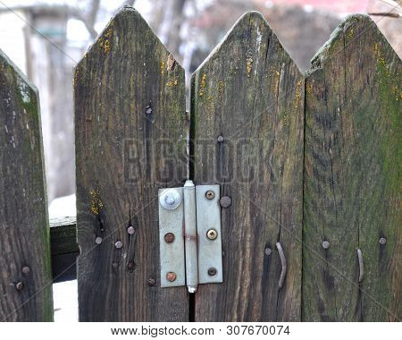 Old Wooden Fence With Hammered Bent Nails, A Loop From The Gate.