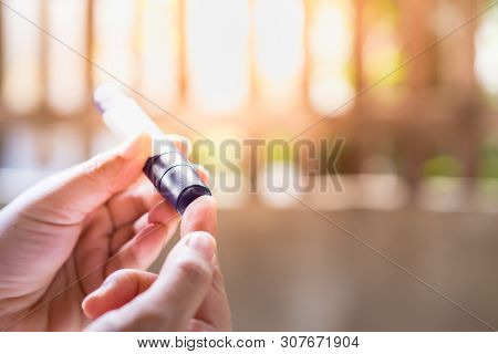 Close Up Of Woman Hands Using Lancet On Finger To Check Blood Sugar Level By Glucose Meter In The Mo