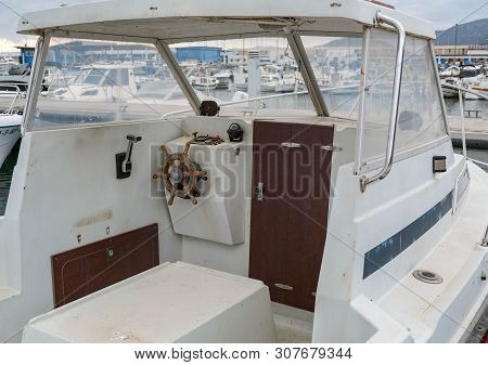 View On The Cockpit Of The Boat, Old Steering Wheel. Wheelhouse Of The Small Motorboat. Wood Steerin