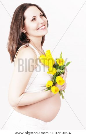 Retrato hermosa mujer embarazada con tulipanes amarillos