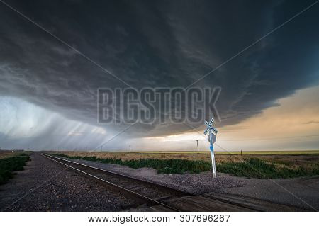 A Large Storm Blows In Over A Railroad Crossing, Dumping Heavy Rain And Producing Extreme Winds.