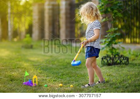 Little Girl Playing Mini Golf In Spring Park. Child Having Fun With Active Leisure On Vacations. Bab